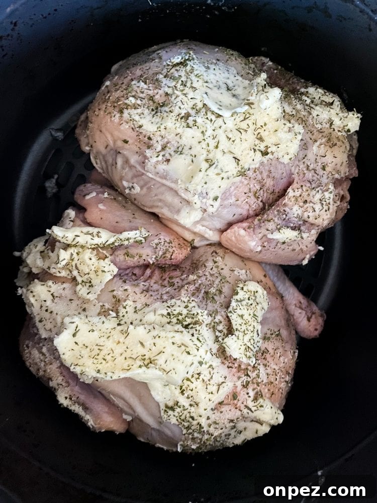 Crispy Air Fryer Cornish Hens Recipe with Herb Butter 8 raw cornish game hens in an air fryer basket with butter and seasonings