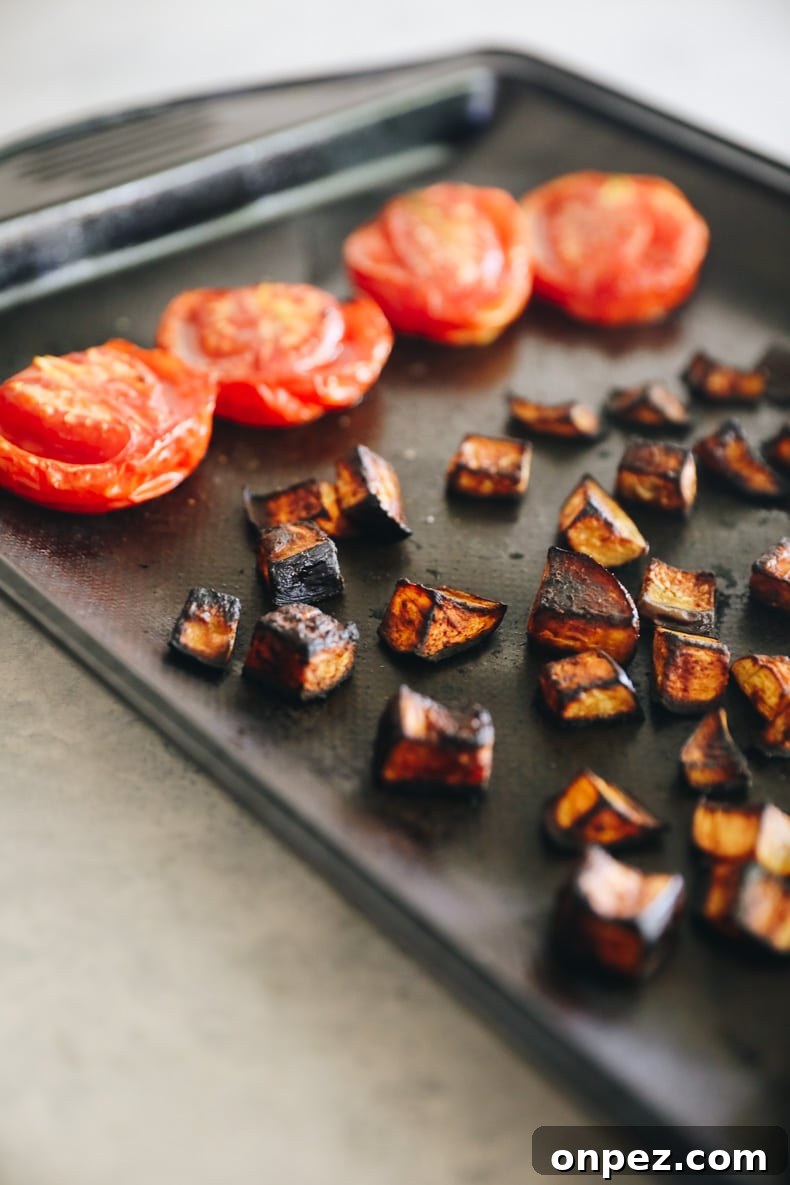 Roasted eggplant and tomatoes on a baking sheet