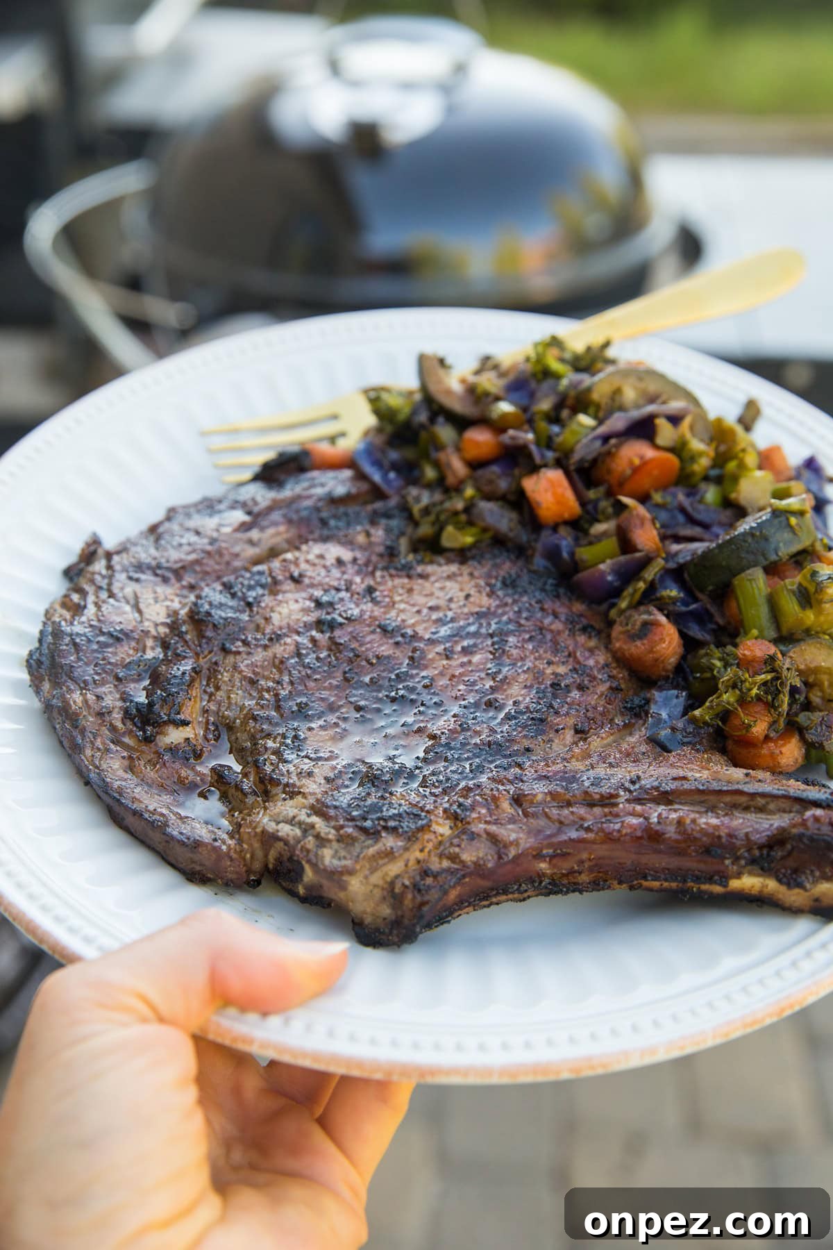 Delicious juicy perfectly grilled bone-in ribeye steak and veggies