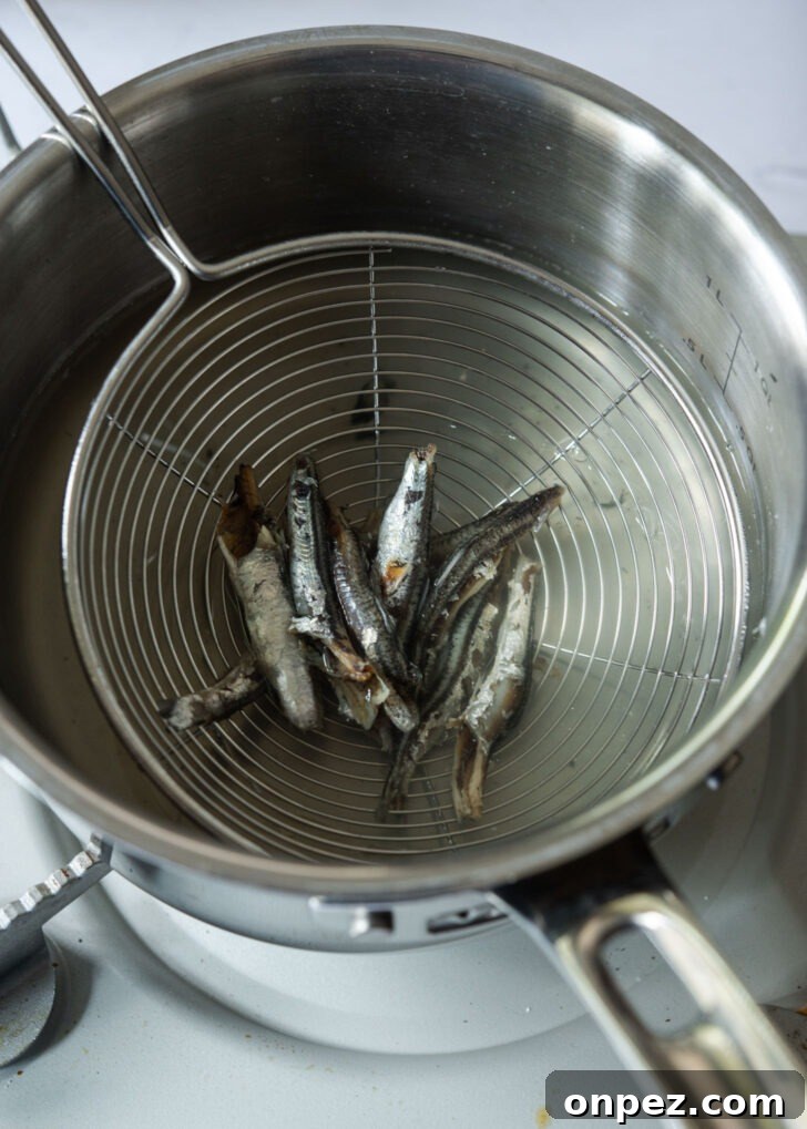 Discarding anchovies from the stock in a pot.