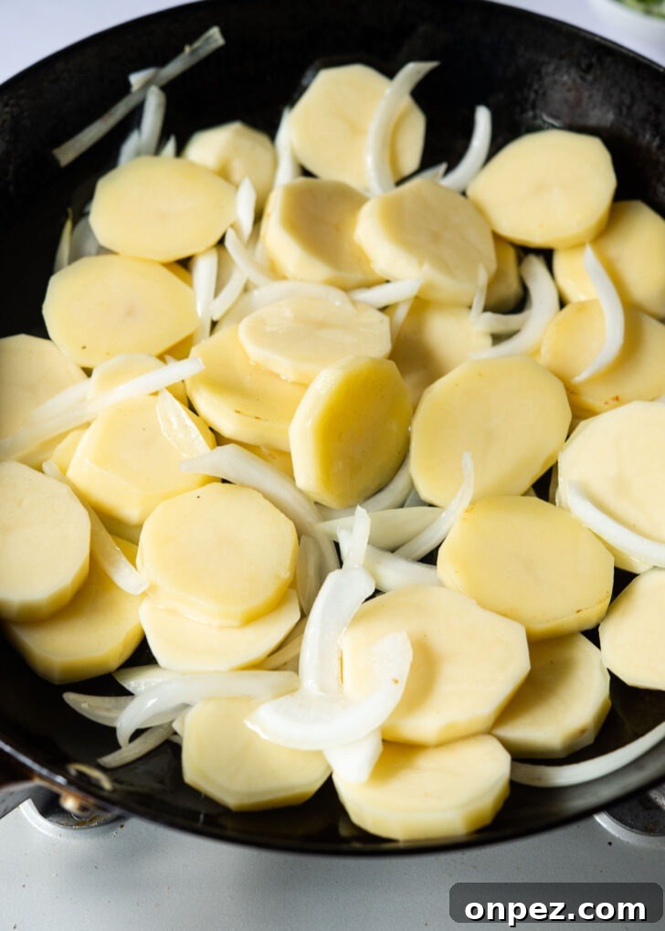 Potato and onion combined in a skillet.