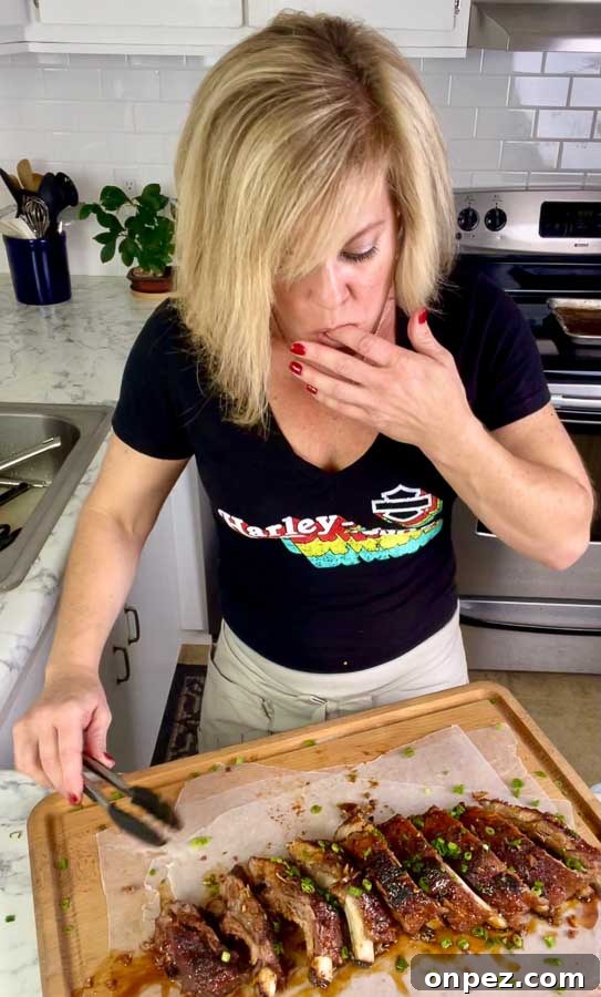 Sticky Asian Baked Pork Ribs Recipe 3 Jennifer cutting ribs on a cutting board