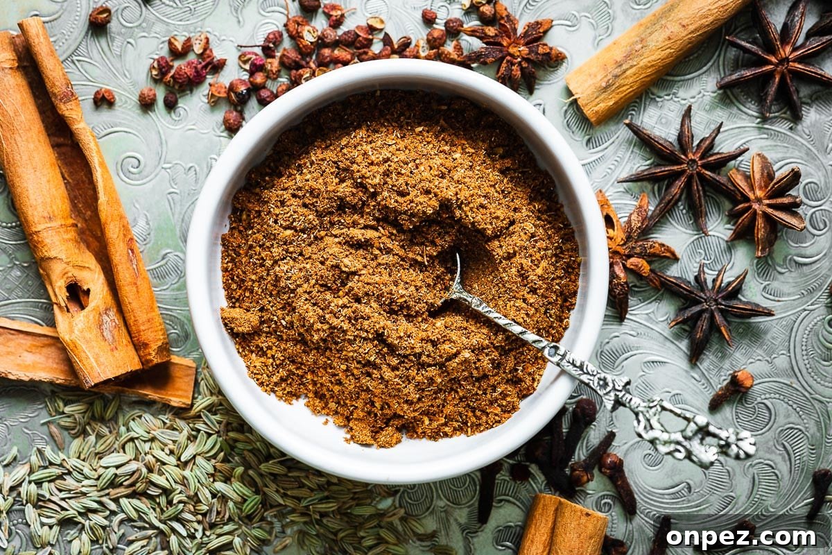 Chinese five-spice powder in a small bowl surrounded by spices viewed from above.