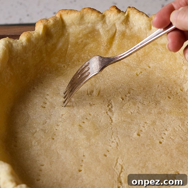 Poking holes in the bottom of a pie crust before baking.