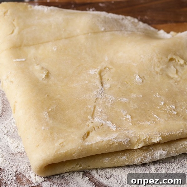 Folding rolled out pie crust pastry before placing it in a pie plate to bake.