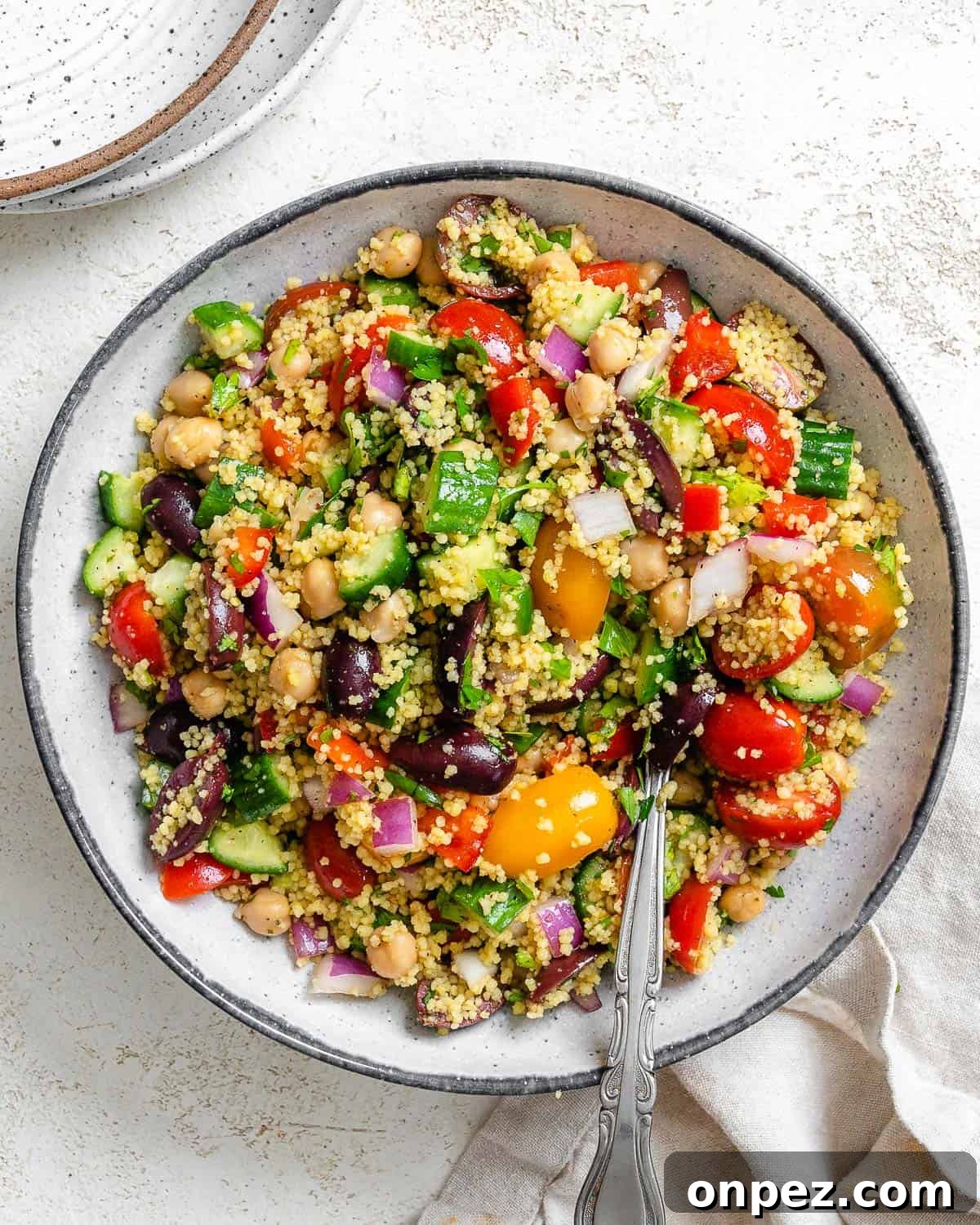 completed Mediterranean Couscous Salad plated against a white surface