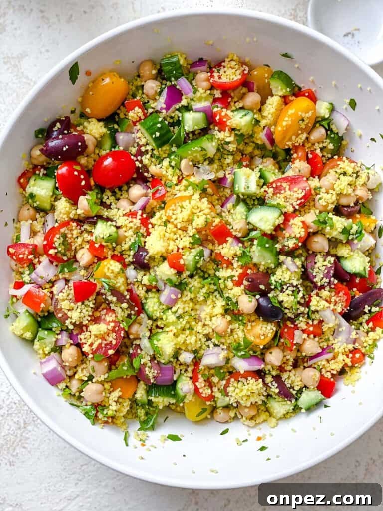 process shot of mixing couscous and veggies together in bowl