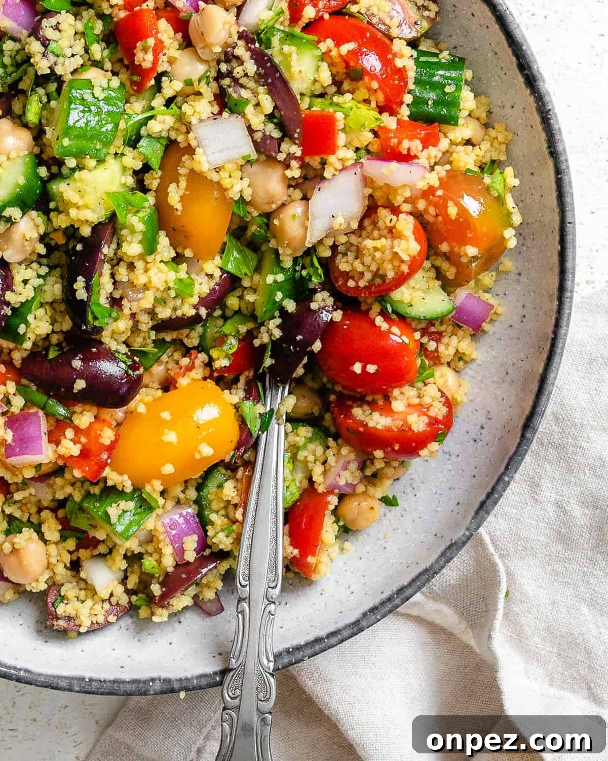completed Mediterranean Couscous Salad plated against a white surface