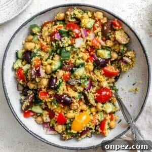 completed Mediterranean Couscous Salad plated against a white surface