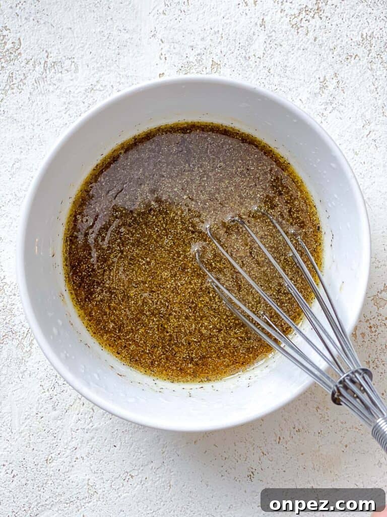process shot of whisking dressing in a white bowl