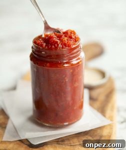 Tomato Chutney in a Jar chutney in a clear jar with teaspoon popping out the top