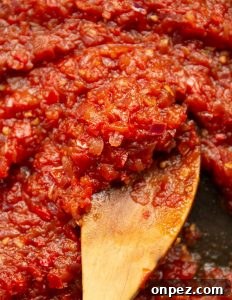 Tomato Chutney in Saucepan overhead shot of chutney in saucepan with wooden spoon scooping in