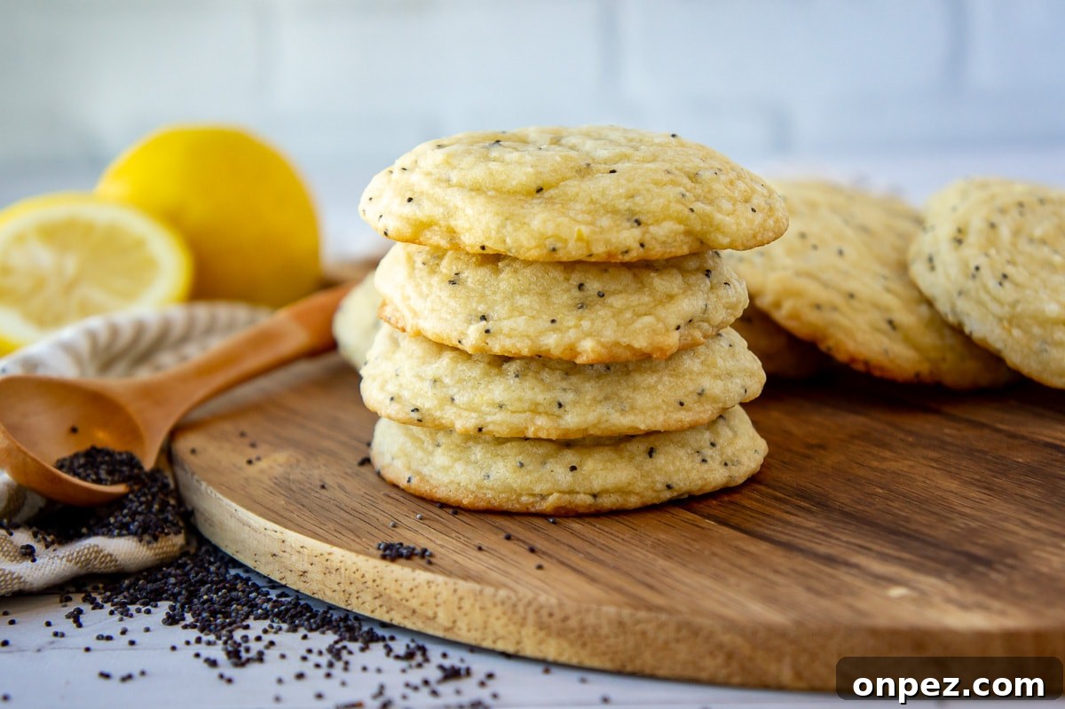Lemon Poppy Seed Cookies with Bright Zesty Flavor 6 a stack of sugar cookies with poppy seeds and a lemon in the background.