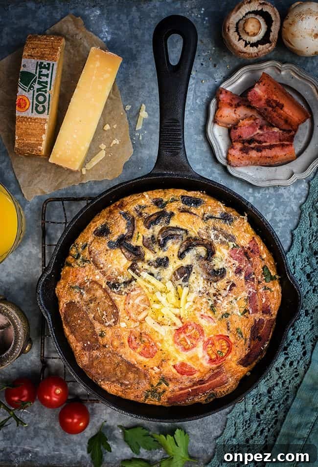 Fully Loaded Deep Dish Breakfast Frittata with Comté Cheese, Bacon, Sausages, Tomatoes and Mushrooms - perfect for breakfast, brunch or lunch.