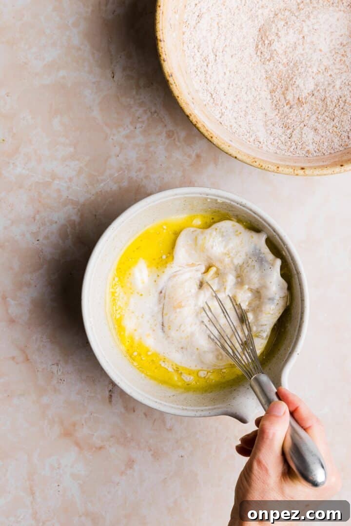 Moist Honey Bran Muffins Recipe 6 Wet ingredients for muffins being whisked together in a large mixing bowl
