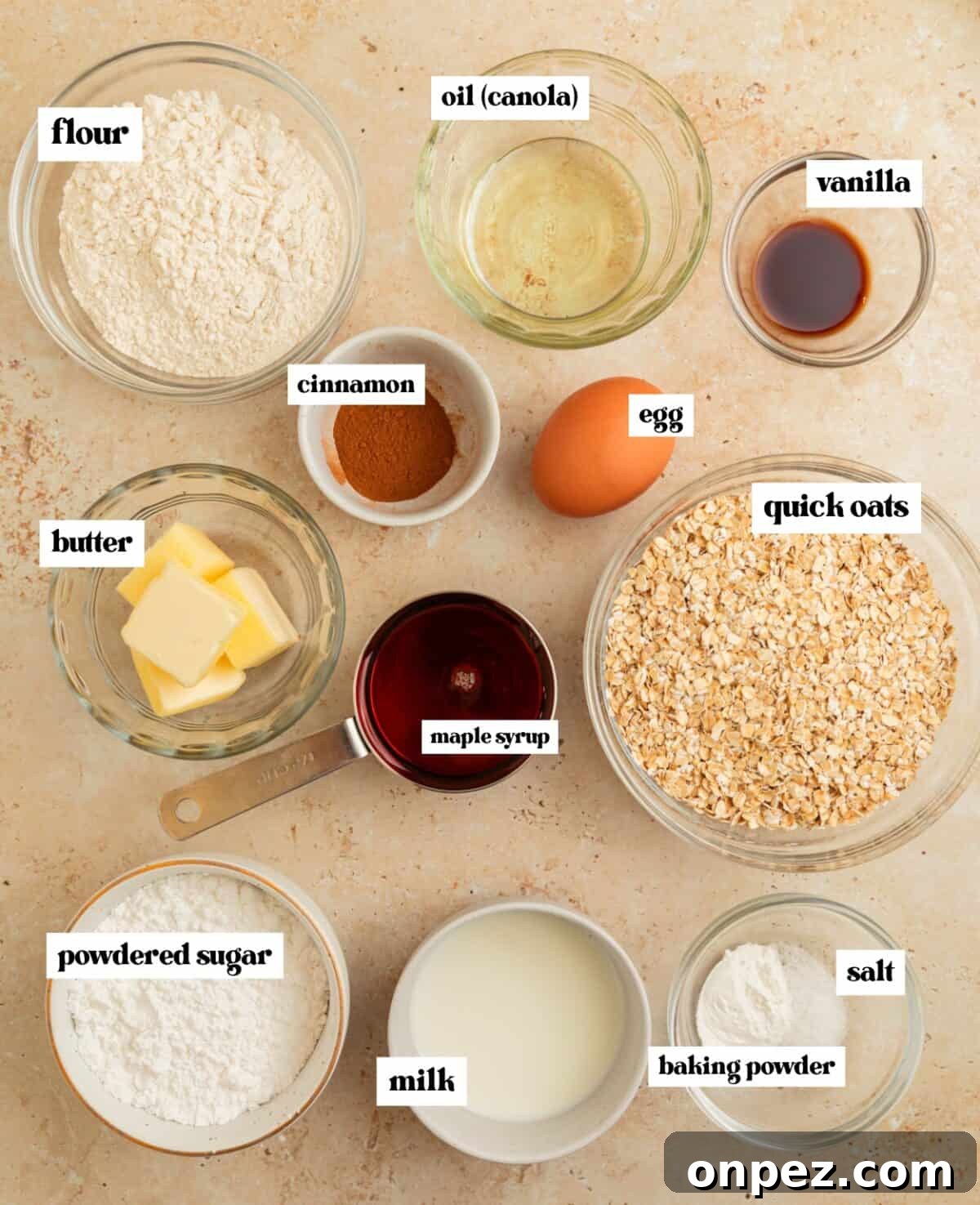 Quick cooking oats, flour, egg, cinnamon and other ingredients arranged on surface.