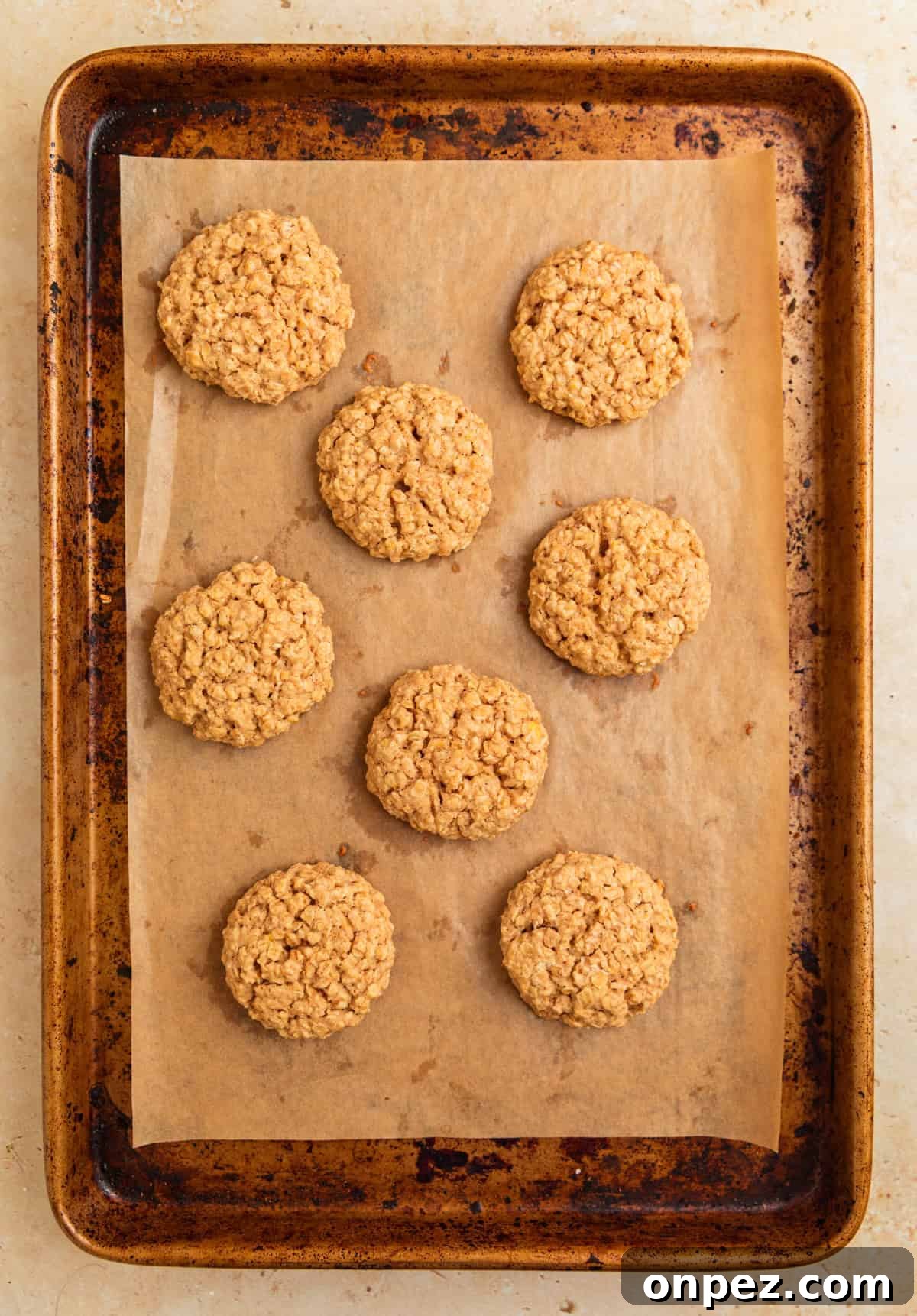 Baked cinnamon roll oatmeal cookies on cookie sheet.