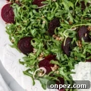 Roasted beet salad on a platter next to a napkin.