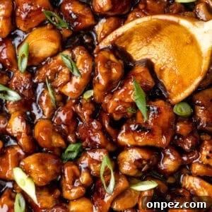Bourbon Chicken Recipe with Sweet Sticky Sauce 2 A wooden spoon stirring homemade bourbon chicken