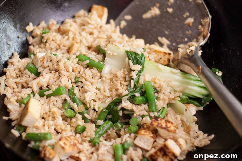 Thai fried rice with tofu beans and pak choi in a wok