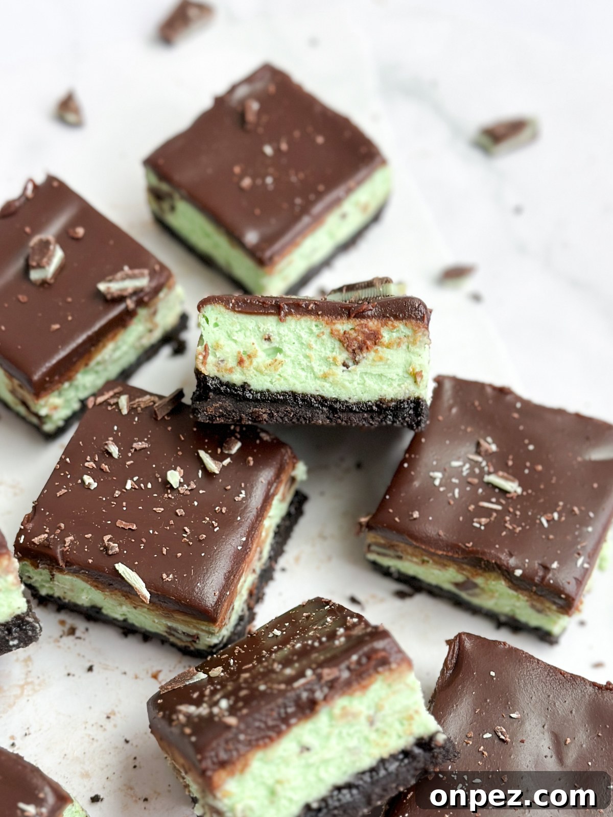Decadent Chocolate Mint Cheesecake Bars 15 a bunch of chocolate mint cheesecake bars stacked and scattered.