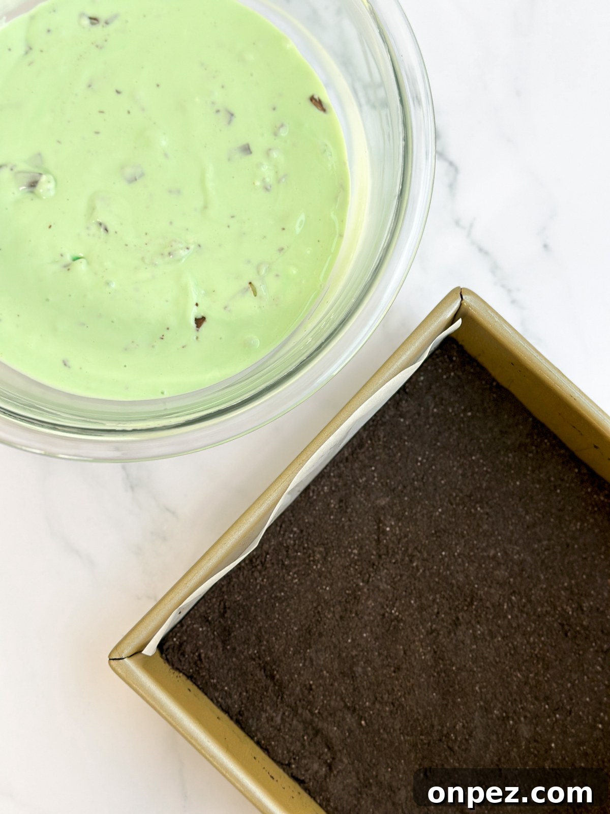 Decadent Chocolate Mint Cheesecake Bars 3 a bowl of cheesecake batter and the crust in the baking pan.