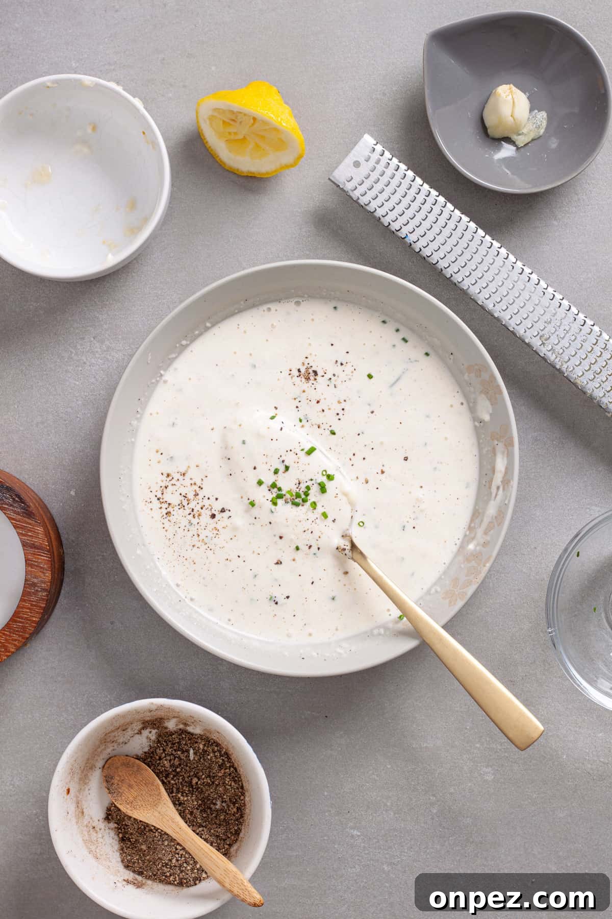 Creamy Horseradish Aioli Recipe for Roasts & Sandwiches 5 A small mixing bowl with horseradish aioli stirred until smooth and topped with chopped fresh chives.