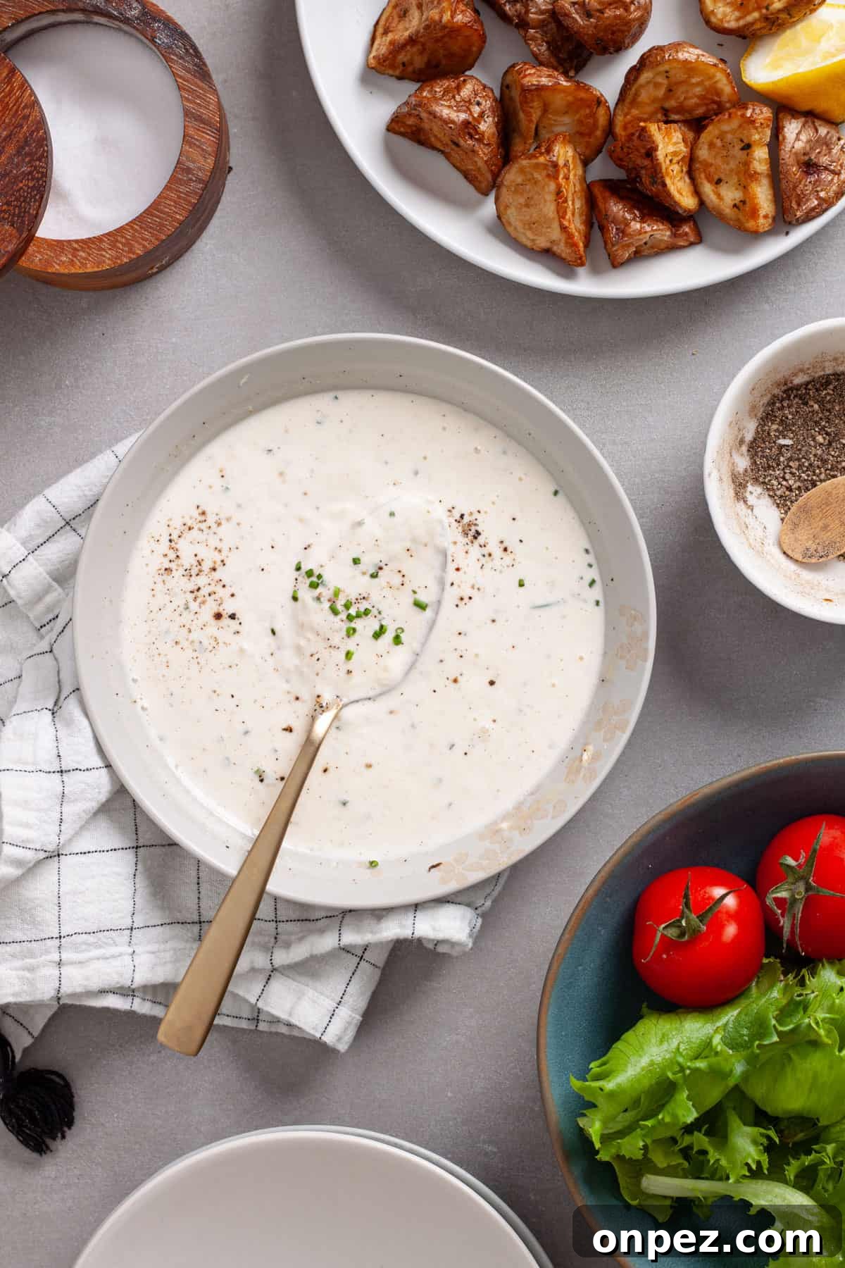 Creamy Horseradish Aioli Recipe for Roasts & Sandwiches 6 A bowl of horseradish aioli with a salad to the side and crispy roasted potatoes to the other side.