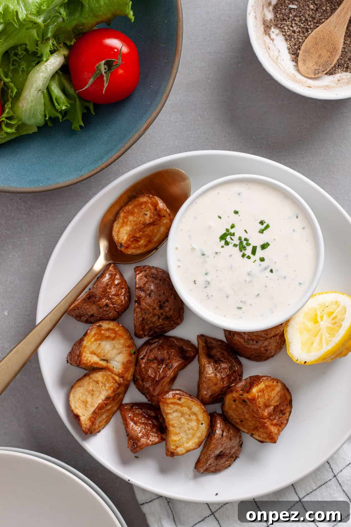 Creamy Horseradish Aioli Recipe for Roasts & Sandwiches 8 A plate of roasted potatoes with a small bowl of horseradish aioli to the side.