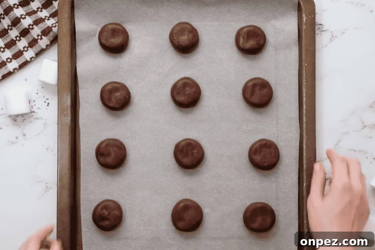 Hot Cocoa Cookies Recipe: Rich Chocolate Chip Cookies 9 portioned hot chocolate cookies on a baking sheet before baking.