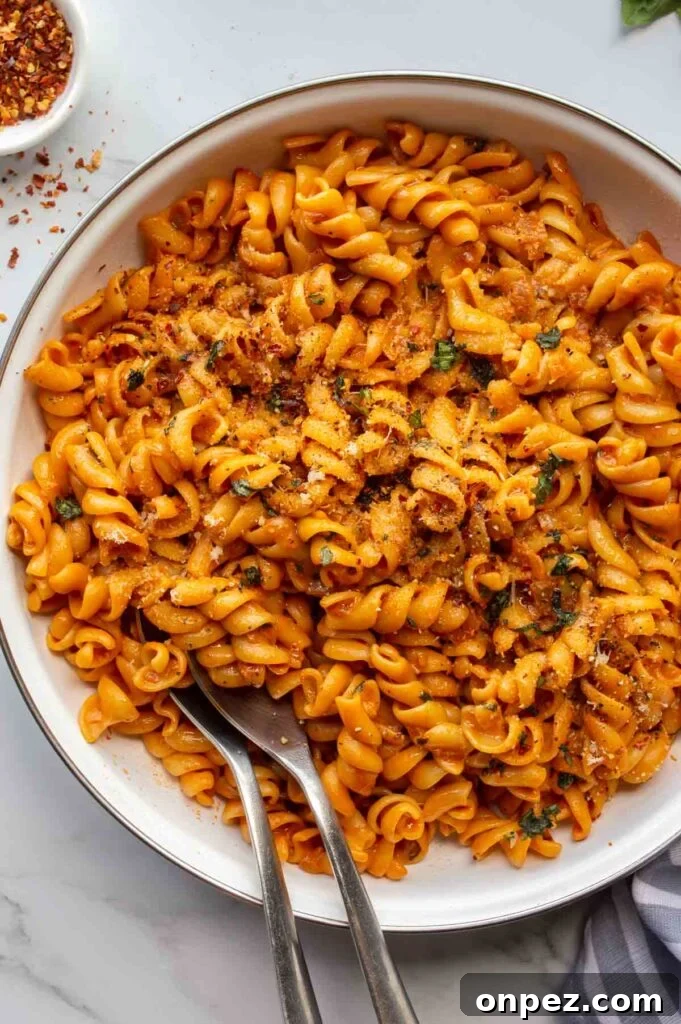 20-Minute Creamy Vegan Tomato Pasta 2 white pan with orange saucy pasta on a white background.