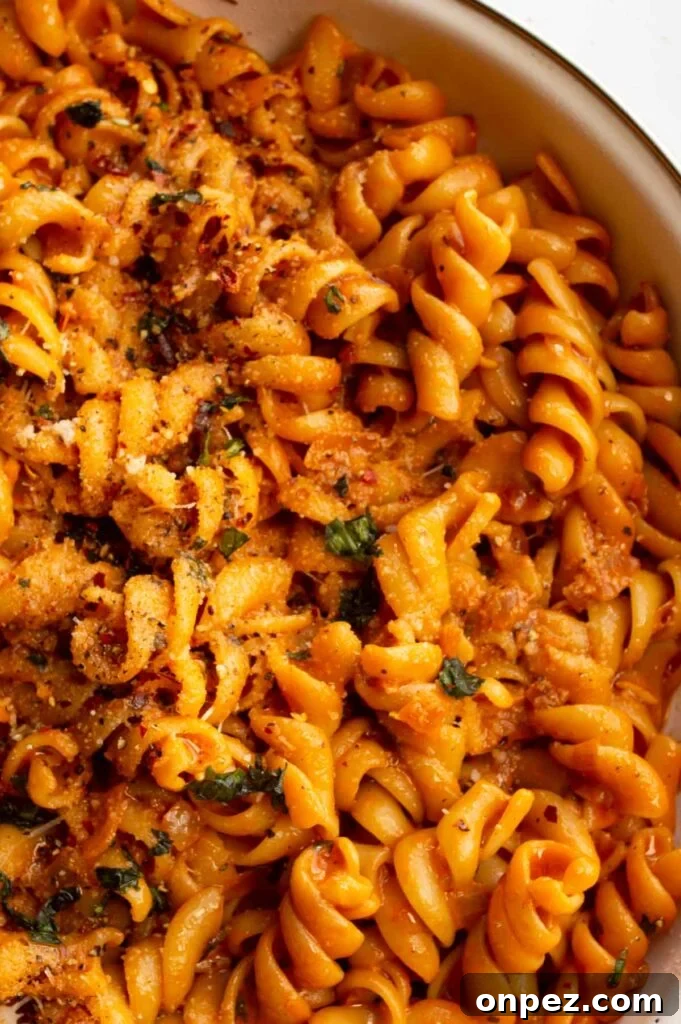 20-Minute Creamy Vegan Tomato Pasta 4 Closeup overhead of pasta coated in a creamy orange sauce.