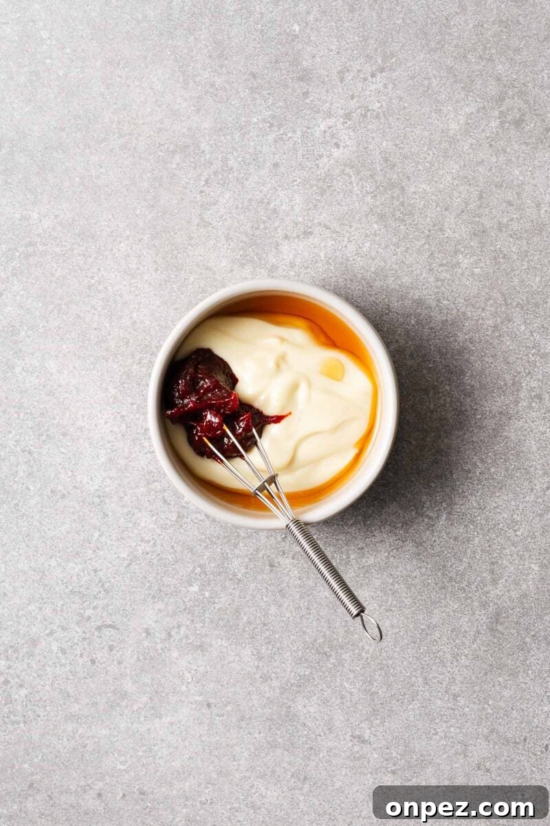 Gochujang mayo ingredients in a small bowl including mayonnaise, gochujang, and toasted sesame oil.