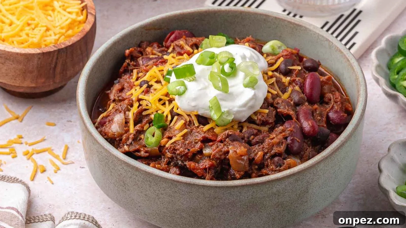 Pulled pork chili simmered thick with smoky shredded pork.