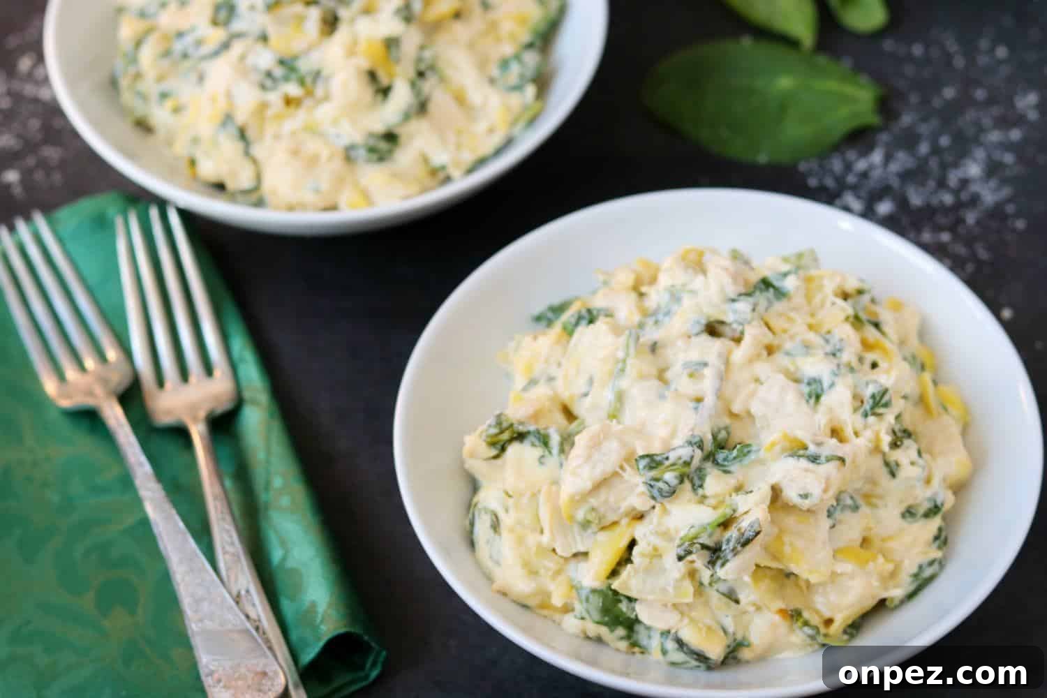 Instant Pot Spinach and Artichoke Chicken 2 White bowl filled with chicken, spinach, artichokes, and kale