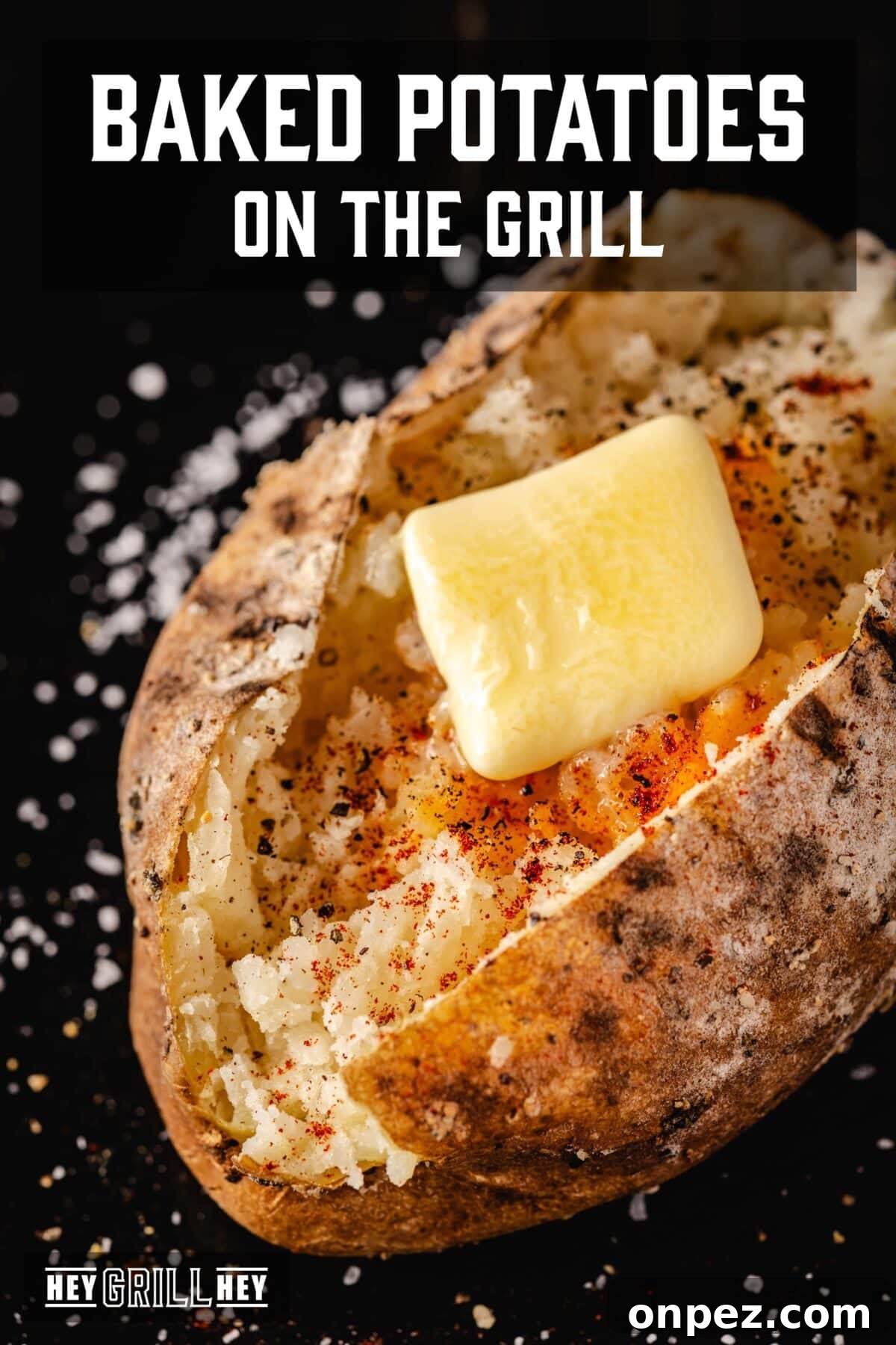 How to Grill Baked Potatoes with Crispy Skin 2 A baked potato topped with a butter pat. The text overlay reads "Baked Potatoes on the Grill" at the top, and "Hey Grill Hey" at the bottom.