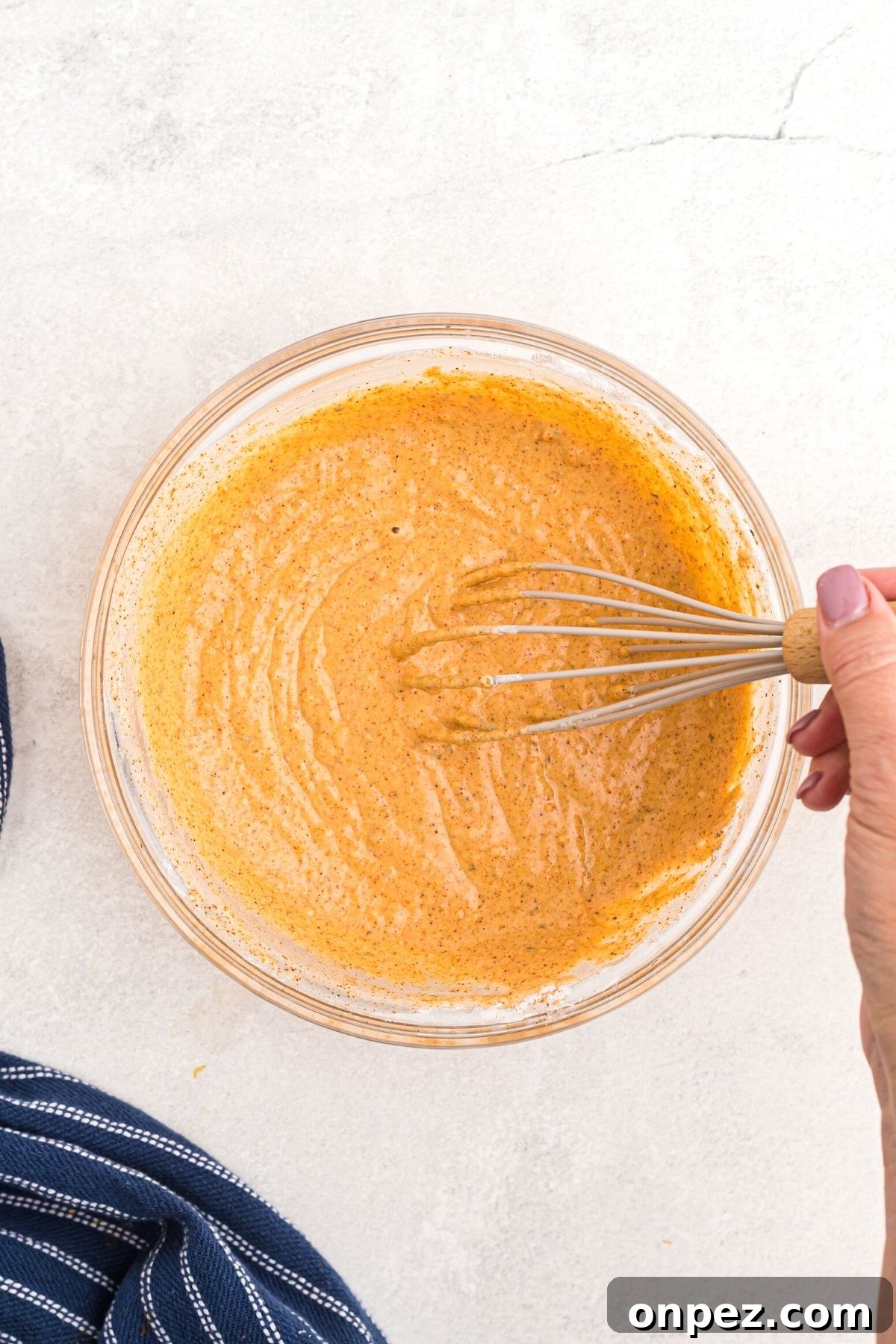 Glass bowl with flour and seasoning mixed into a batter