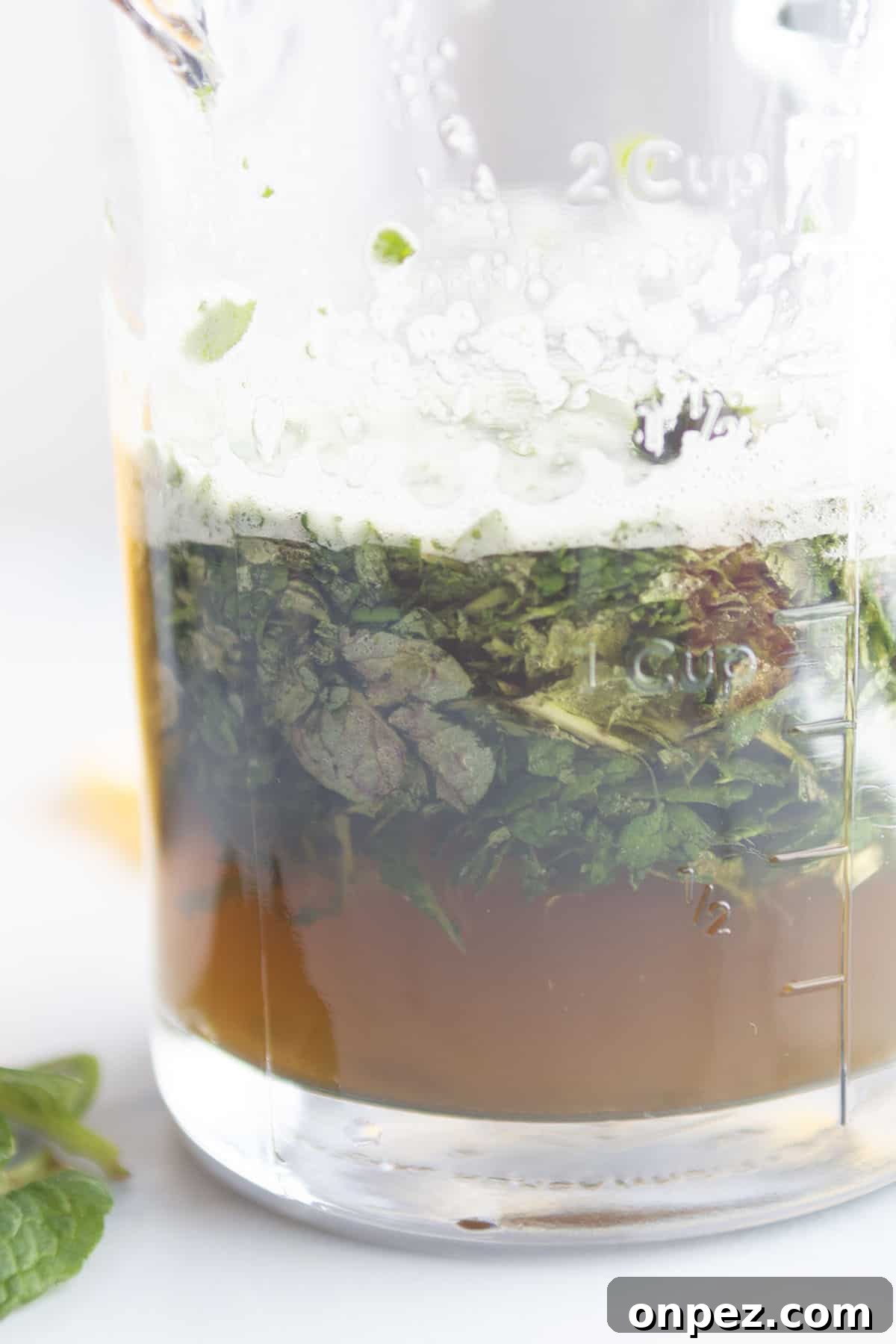 A glass jar with mint and water.