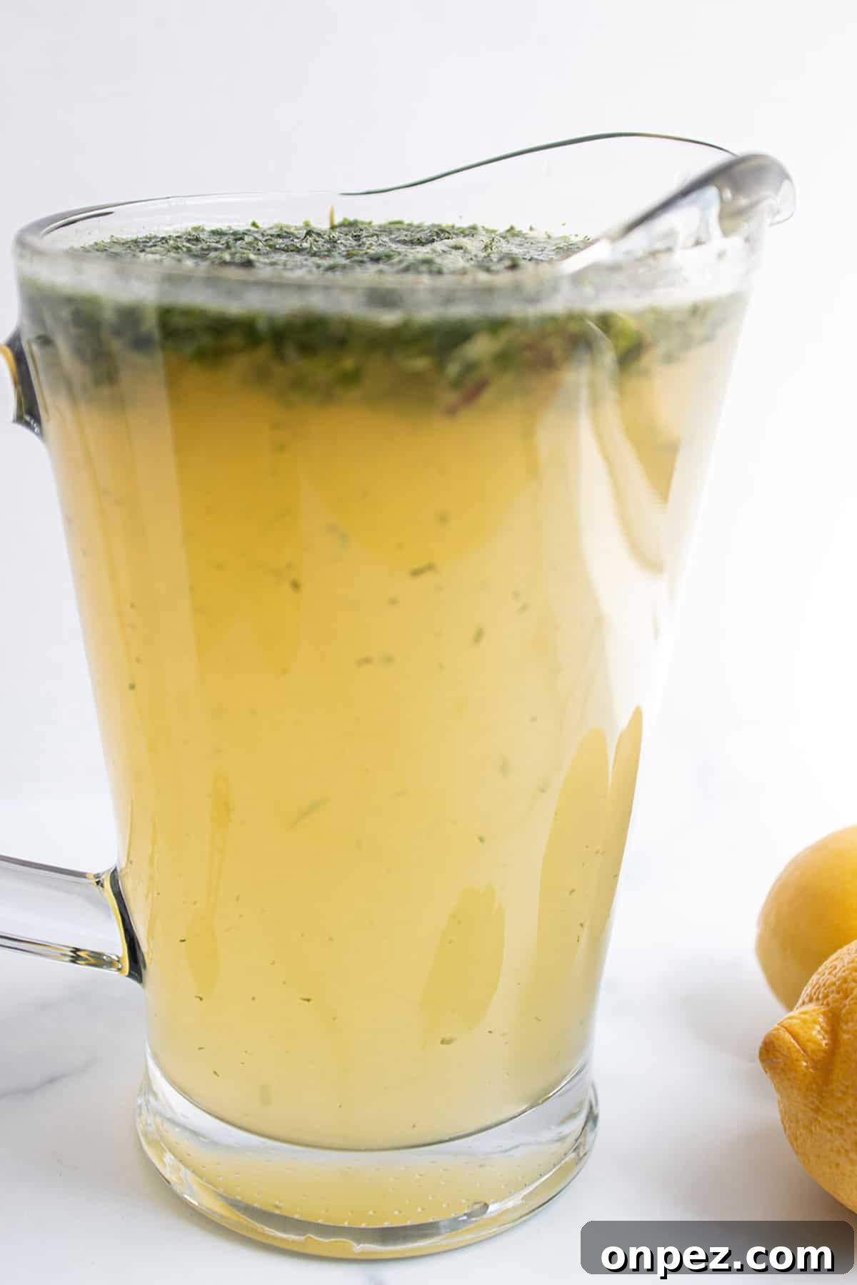 A pitcher with lemonade and fresh mint leaves.