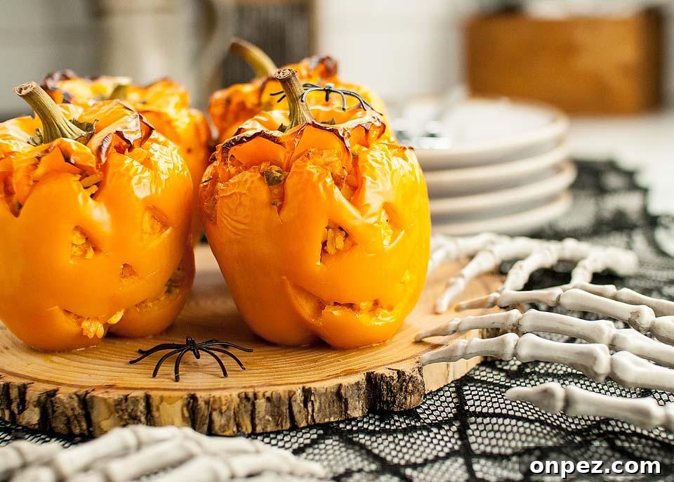 Buffalo Chicken Jack-O-Lantern Stuffed Peppers on a wood cutting board 