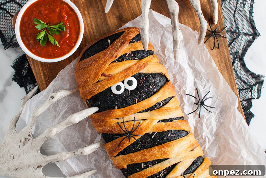Halloween Mummy Stromboli with candy eyes and sauce on the side 