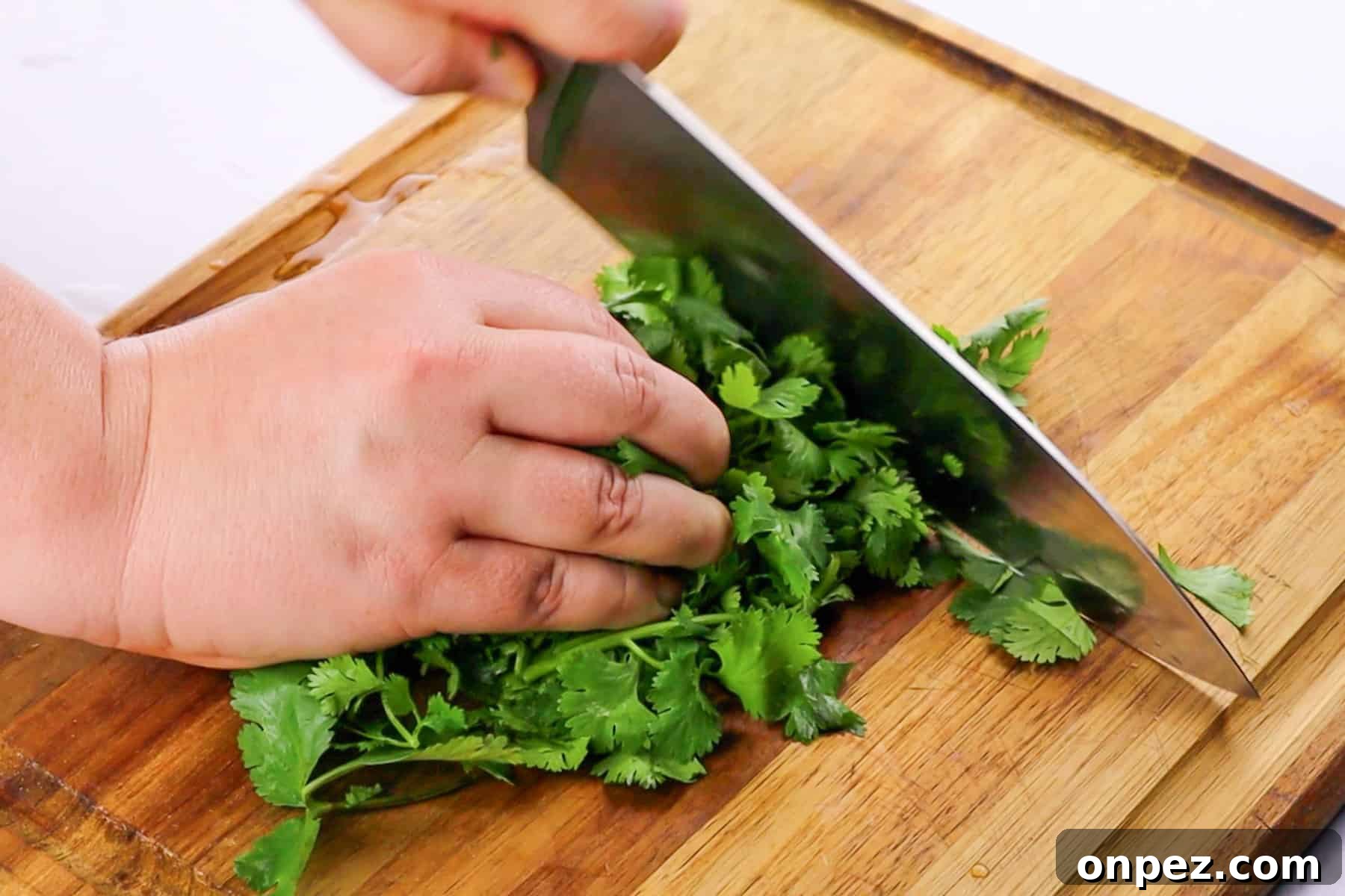 How to Chop Cilantro and Keep It Fresh 6 cutting the cilantro on wooden cutting board with chef knife